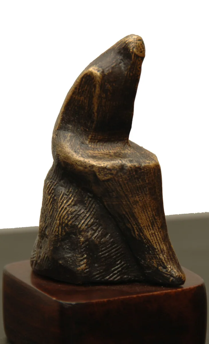 Bronze B32, 2009–2010. Bronze. Bronze of a seated, hunched figure with a textured surface, on a wooden plinth.